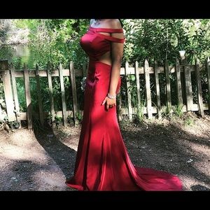 Beautiful backless red dress with long trail.